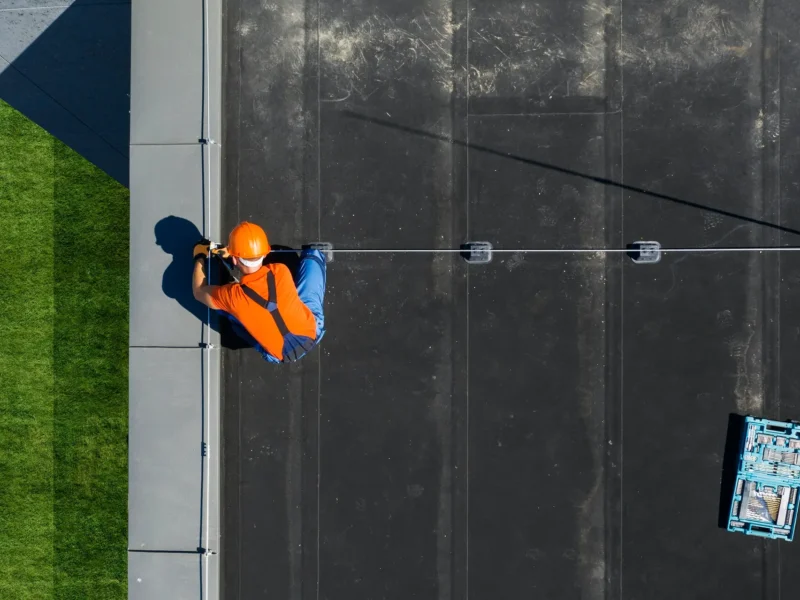 Technician Installing Lightning Protection Rod on Top of Building